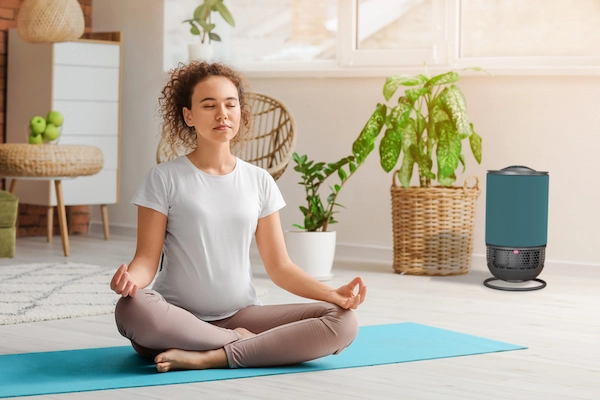 Schwangere Frau Yoga mit Luftreiniger Aeroguard